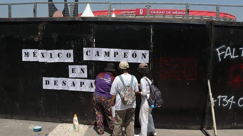 Con un ajolote y una pala “mundialista” familias pegan fichas de búsqueda cerca del Estadio Azteca